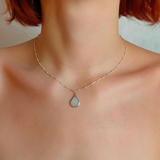 Colgante de Plata de Ley y Nácar, con un diseño intemporal donde una pieza con forma de gota, de nácar, se realza por un borde d