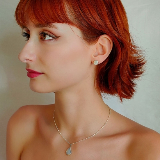 Pendientes de Plata de Ley y Nácar, con un diseño intemporal donde una pieza redonda de nácar se realza por un borde de plata qu