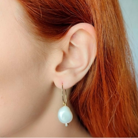 Atractivo pendiente con gancho de Plata de Ley chapado de oro del que cuelga una bonita perla natural barroca con forma de lágri